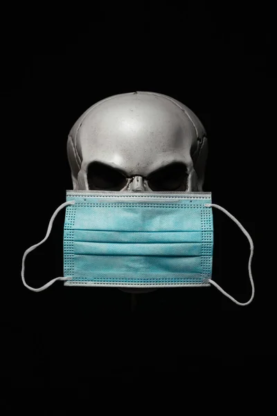 Human skull wearing a surgical mask. Isolated on black background.