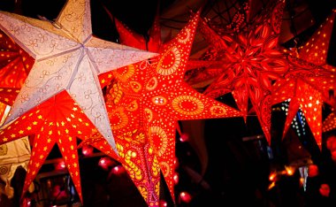 İtalya, Floransa 'da bir Noel pazarında asılı duran entrika desenli kırmızı beyaz kağıt yıldız süslemeleri mevsimlik cazibe yayıyor.