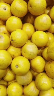 Süpermarkette bir rafta tam ve dilimlenmiş greyfurtlar.