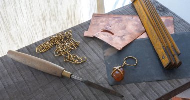 Zincir ve mücevher yapmak için bir zanaatkarın masasındaki aletler..