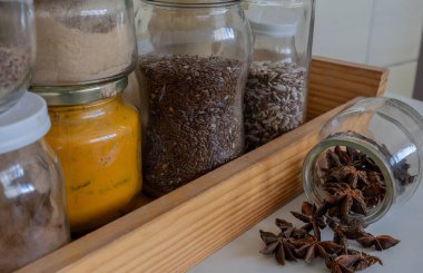 Farklı baharatlı kavanozların yanında anason yıldızları olan açık bir kavanoz. Uzun ömürlü