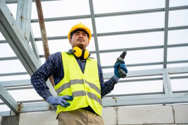 İnşaat alanında matkap kullanan bir işçinin yakın çekimi..