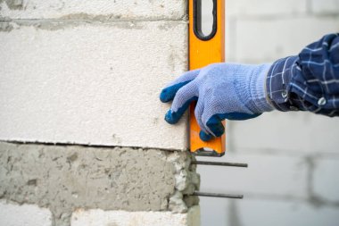 Masonluk işçisi beton yapar, tuğla döşeme düzeyi dikey ve pürüzsüz tuğla işçiliğini kontrol etmek için kullanılır.