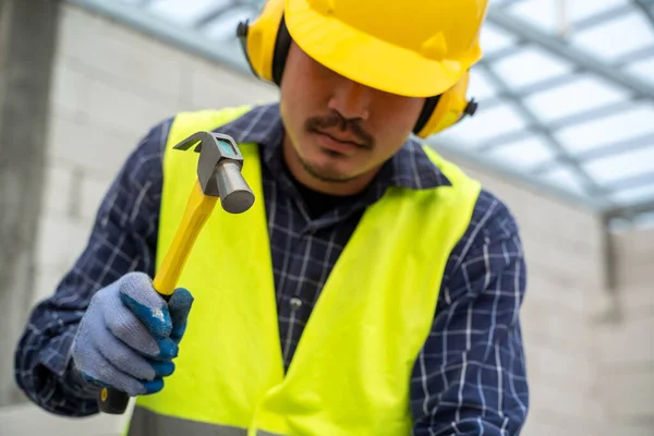 工业工人在在建房屋中建筑外墙 用铁锤在水泥中砌筑砖 — 图库照片