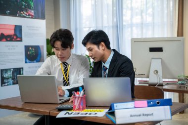 Asyalı iş adamları birlikte çalışıyor ve mevcut ve birlikte çalışıyorlar. Lütfen yeni personeli ofiste eğitin.. 