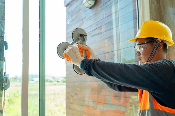 Rakennustyöntekijät Asentamassa Ikkunaa Uuteen Rakennukseen Kädessä Erityinen Työkalu Lasin Kuljettamiseen — kuvapankkivalokuva