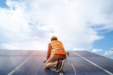Güneş enerjisi santralinin yedek güneş paneli üzerinde çalışan mühendis veya elektrikçi, yaşam için yeşil enerjinin icadına güneş enerjisi santrali kavramını benimsedi.