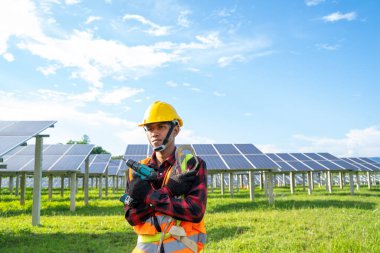 Güneş enerjisi santralinin yedek güneş paneli üzerinde çalışan mühendis veya elektrikçi, yaşam için yeşil enerjinin icadına güneş enerjisi santrali kavramını benimsedi.