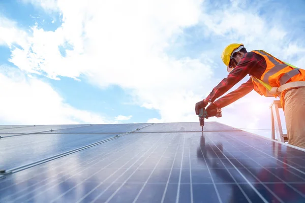 Solar panel technician with drill installing and maintenance solar panels on roof at solar power plant,Solar panel,Alternative electricity source.