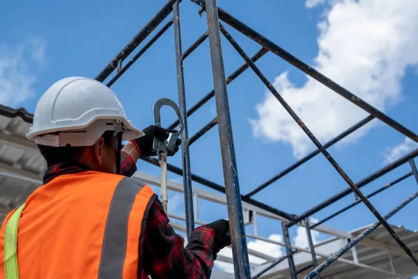 Byggnadsarbetare Som Bär Säkerhetssele Och Säkerhetslinje Med Verktyg Klättrar Byggnadsställningar — Stockfoto