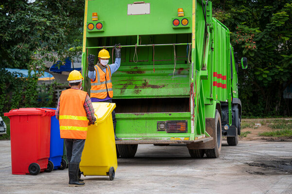 Garbage collection service,Rubbish cleaner man in a uniform working together on emptying dustbins for trash removal with truck loading waste and trash bin,Recycling concept.