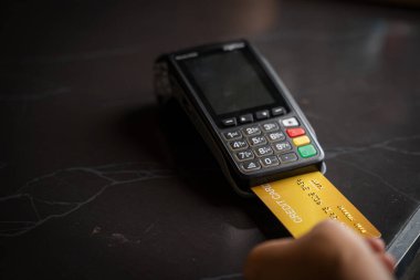 Müşteri ödeme terminali üzerinden garson, kredi kartı ödemesi, ürün alıp satma hizmetleri üzerinden ödeme yapıyor.