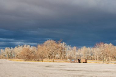 Otobanın üzerindeki güzel koyu mavi gökyüzü. Alışılmadık bir gökyüzü, yapraksız ağaçlar ve fırtınadan önceki bir sonbahar gününde asfalt bir yol. Pacific Junction, IA, ABD, 11-30-2019