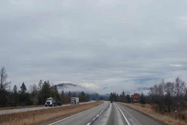 Karayolu Kışın Bulutların Arasında Yüksek Dağların Arasında Yol Işaretleri Olan — Stok fotoğraf