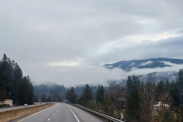 Karayolu Kışın Bulutların Arasında Yüksek Dağların Arasında Yol Işaretleri Olan — Stok fotoğraf