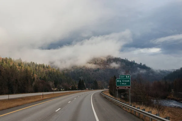 Autobahn Mit Straßenschildern Den Seiten Zwischen Hohen Bergen Den Wolken — Stockfoto