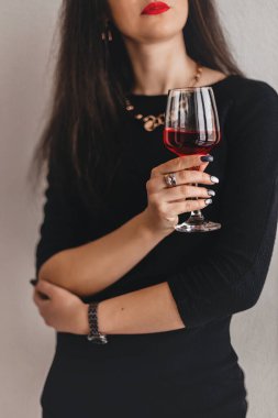 Güzel bir kızın ellerinde bir kadeh kırmızı şarap.