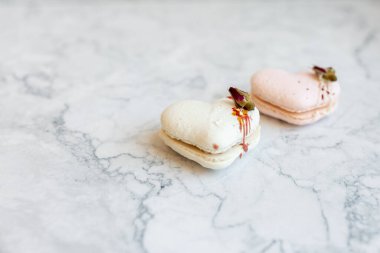 Macaroons close up. Pink and white macaroons on the murble table. Background for Valentine's Day