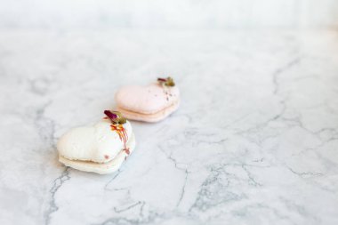 Macaroons close up. Pink and white macaroons on the murble table. Background for Valentine's Day