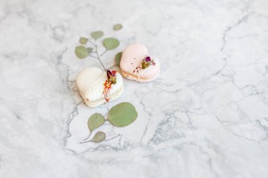Macaroons close up. Pink and white macaroons on the murble table. Background for Valentine's Day