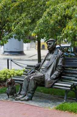 Kyiv, Ukrayna - 17 Ağustos 2025: Ukraynalı aktör Mykola Yakovçenko anıtı, köpeği Fan-Fan ile birlikte İvan Franko Ulusal Tiyatrosu yakınlarında bronz bir bankta oturuyordu.