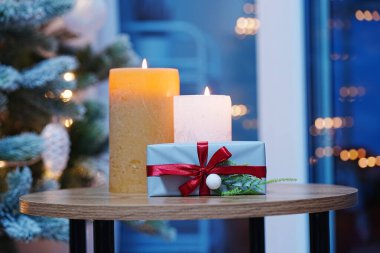 Noel mumları ve hediye kutusu. Kış mevsiminde şenlikli ışıklar.
