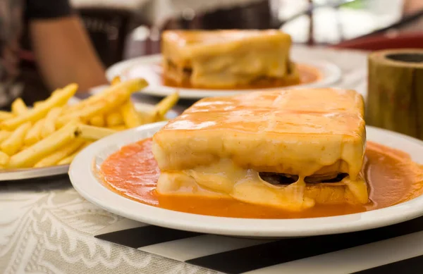 Francesinha - typical portuguese food - the toast bread with the sausage, the pork meat, and the melted cheese in the tomato sauce - Porto - Portugal