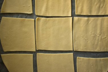 Kahverengi yumurtaların yakın çekimi ve koyu ahşap bir tahta üzerinde bir un yığını. Moody sade ışıklandırma ve zengin dokular sıcak, kırsal ve dramatik bir pişirme atmosferi yaratır..