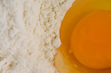 Un kuyusundaki çiğ yumurtanın üst görüntüsü, sıcak tonlarını ve detaylı dokularını yakalıyor. Pişirme, pişirme ve mutfak kavramları için mükemmel..