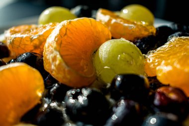 Pavlova kremalı tatlı ve kırmızı frenk üzümü, yabanmersini ve narenciye dilimleri de dahil olmak üzere taze böğürtlenler. Parlak yönlü ışık dokuları ve renkleri güçlendirir.