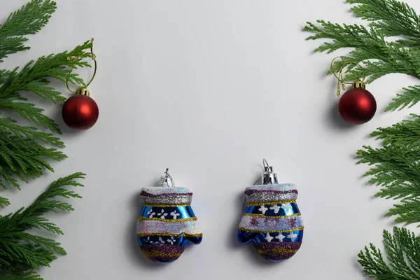 Yeni yıl kartı. Yeşil ağaçların arasında eldivenler var..