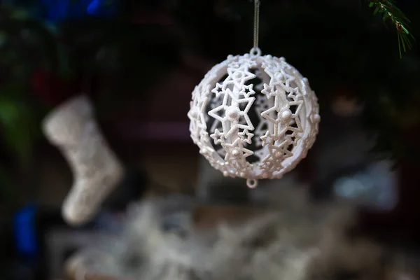 Beyaz yuvarlak yeni yıl oyuncağı ağaçta asılı. Yerel odak