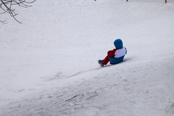 The child slides down the snow slide.
