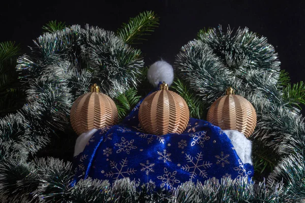 Yellow Christmas balls on a background of decorated Christmas tree branches