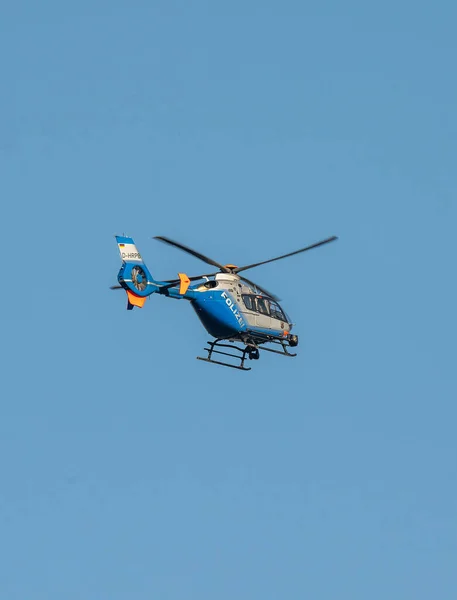Alemania Koblenz 05.04.2020 D-HRPB helicóptero de policía vuela sobre la ciudad en el fondo del cielo azul en busca de sospechoso —  Fotos de Stock