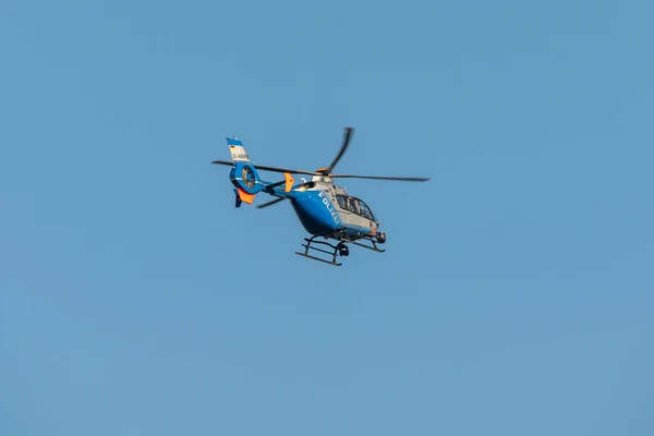 Germany Koblenz 05.04.2020 D-HRPB police helicopter flies over the city in blue sky background searching for suspect — Stock Photo, Image