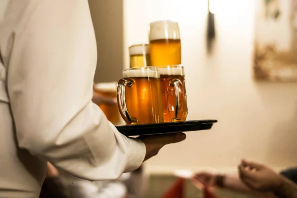 Diverse bevande di birra su un piatto servito dal cameriere in un giardino di birra biergarten tedesco — Foto Stock