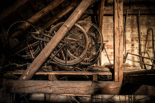 A rusty old vintage bikes in a barn with old farm machinery — Stock Photo, Image