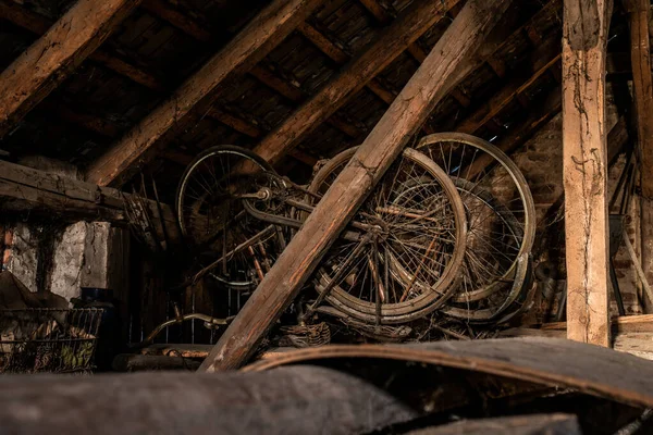 A rusty old vintage bikes in a barn with old farm machinery — Stock Photo, Image