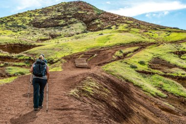 Portekiz 'in Madeira adası, Ponta de Sao Lourenco Atlantik Körfezi' nin kıyısında kayalık uçurumlara tırmanan bir kız.