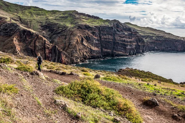 Portekiz 'in Madeira adası, Ponta de Sao Lourenco Atlantik Körfezi' nin kıyısında kayalık uçurumlara tırmanan bir kız.
