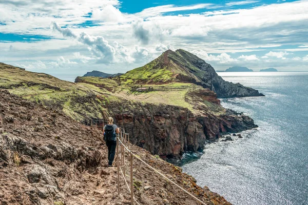 Portekiz 'in Madeira adası, Ponta de Sao Lourenco Atlantik Körfezi' nin kıyısında kayalık uçurumlara tırmanan bir kız.