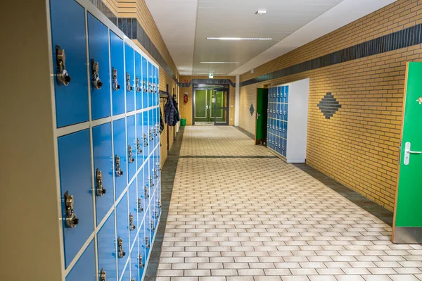 Sala de aula do corredor do corredor limpo vazio com armários coloridos da mobília e quarto da porta na escola ou na universidade em alemanha — Fotografia de Stock