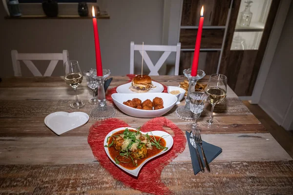 Валентайни святкують день, ставлячи романтичну любов до двох дерев'яних столів червоного кольору серця свічки з Бургером і Пастою. — стокове фото