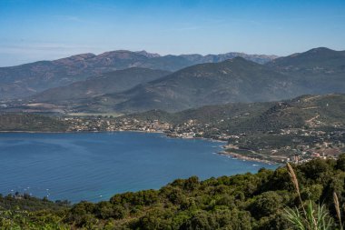 Sagone Korsika 'daki muhteşem golf sahili güzel kumsal tekneleri ve dağ köyü turizmi ve tatil konsepti