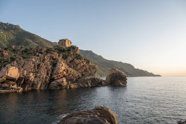 Gökyüzü manzaralı kasaba ve Fransa 'nın Porto, Korsika kentindeki Ceneviz kulesinin kalıntıları Akdeniz' e bakan ortaçağ gözetleme kulesi de Piana