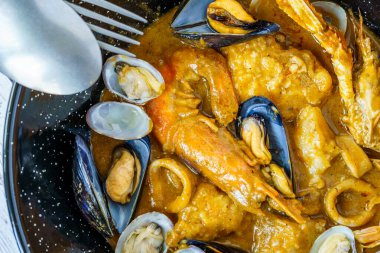 İspanyol Suquet de Peix deniz çorbası, patates, karides, midye, otlar ve tabakta Picada olan balık.