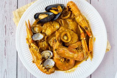 Katalan otantik Suquet de Peix çorbası, patates, karides, midye, otlar ve tabakta yakın plan pikad tabağı. Yukarıdan yatay üst görünüm