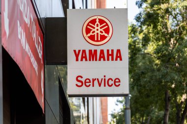 Barcelona, Spain-August 9, 2025. Yamaha service sign on a building exterior with trees nearby.