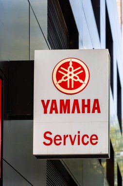Barcelona, Spain-August 9, 2025. Yamaha service sign on a building exterior with trees nearby.